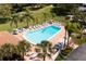 Aerial view of a community pool with palm trees and lounge chairs at 1278 Mission Cir # 45B, Clearwater, FL 33759