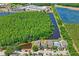 An aerial view showcasing a neighborhood featuring lush greenery, serene ponds, and a school nearby at 12935 Solola Way, Trinity, FL 34655