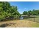 Beautiful backyard view with a fence and a serene pond surrounded by lush greenery at 12935 Solola Way, Trinity, FL 34655