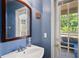 Bright bathroom with blue walls, a sink and a view of the outdoor patio through a glass paneled door at 12935 Solola Way, Trinity, FL 34655