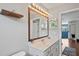 Spacious bathroom with a granite-topped vanity, bright lighting, and decorative mirror at 12935 Solola Way, Trinity, FL 34655