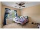 Bedroom with a ceiling fan, window, and cozy decor creates a welcoming atmosphere at 12935 Solola Way, Trinity, FL 34655