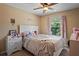 Bedroom with ceiling fan, dresser and window, creating a comfortable living space at 12935 Solola Way, Trinity, FL 34655