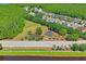 Aerial view of community playground surrounded by lush trees, with houses in the background and a roadside path at 12935 Solola Way, Trinity, FL 34655