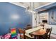 Dining room featuring a modern light fixture, a blue accent wall, and natural light at 12935 Solola Way, Trinity, FL 34655