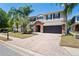 Charming two-story home with a brick driveway, manicured lawn, and a three car garage at 12935 Solola Way, Trinity, FL 34655
