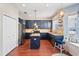 Stylish kitchen featuring blue cabinets, stainless steel appliances, an island, and beautiful hardwood floors at 12935 Solola Way, Trinity, FL 34655