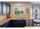 Modern kitchen featuring blue cabinets, stainless steel appliances, granite countertops, and stainless-steel dishwasher at 12935 Solola Way, Trinity, FL 34655