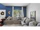 Bright living room featuring a large sectional sofa, decorative pillows, and a sunlit window at 12935 Solola Way, Trinity, FL 34655