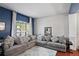 Comfortable living room showcasing a large sectional sofa, decorative pillows, and a sunlit window at 12935 Solola Way, Trinity, FL 34655