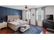 Comfortable main bedroom with a blue accent wall, decorative rug, and a ceiling fan at 12935 Solola Way, Trinity, FL 34655