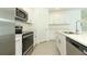 Bright kitchen featuring stainless steel appliances, white cabinetry, and a spacious island at 13261 Tropical Breeze Way, Hudson, FL 34669
