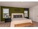Comfortable bedroom with plush carpet, accent wall, and natural light from the window at 13273 Tropical Breeze Way, Hudson, FL 34669