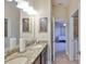 This bathroom has a granite countertop, double sinks, and a mirror over the vanity with views to the bedroom at 13742 Artesa Bell Dr, Riverview, FL 33579