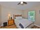 This bedroom features laminate wood flooring, a ceiling fan, and a window with green outdoor views at 13742 Artesa Bell Dr, Riverview, FL 33579
