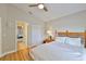 Bright bedroom features light wood flooring, ceiling fan, and a glimpse into another bedroom at 13742 Artesa Bell Dr, Riverview, FL 33579