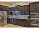 A contemporary kitchen with dark wood cabinetry and stainless steel appliances at 13742 Artesa Bell Dr, Riverview, FL 33579