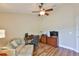 Bright room featuring wood floors, a ceiling fan, comfortable seating, and a functional desk area at 13742 Artesa Bell Dr, Riverview, FL 33579