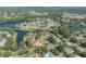 Aerial view shows home in neighborhood near a lake; community with lush trees throughout at 13906 Captains Reef Ct, Tampa, FL 33624