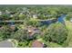An aerial view showcases a beautiful home with a screened pool, backing onto a serene lake and lush landscape at 13906 Captains Reef Ct, Tampa, FL 33624