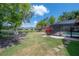 View of the lush backyard, featuring a pond and a screened-in pool area at 13906 Captains Reef Ct, Tampa, FL 33624