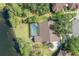 An aerial view features a pool in backyard with well-maintained lawn adjacent to a tranquil lake at 13906 Captains Reef Ct, Tampa, FL 33624