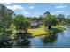 Waterfront home featuring a lush lawn, mature trees, and screened patio for outdoor enjoyment at 13906 Captains Reef Ct, Tampa, FL 33624