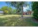 Expansive backyard showcasing lush greenery, trees, and a glimpse of the home's exterior at 13906 Captains Reef Ct, Tampa, FL 33624