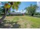 Expansive backyard with lush lawn, screened-in patio, and mature trees provides a serene outdoor space at 13906 Captains Reef Ct, Tampa, FL 33624