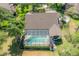 Aerial view features screened-in pool and covered patio of a well-maintained home, complemented by greenery at 13906 Captains Reef Ct, Tampa, FL 33624