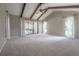 Spacious bedroom with vaulted ceiling, exposed wood beams, carpet floors, and access to a patio at 13906 Captains Reef Ct, Tampa, FL 33624