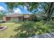 Beautiful front exterior featuring stone accents, lush lawn, and mature trees creating a welcoming curb appeal at 13906 Captains Reef Ct, Tampa, FL 33624