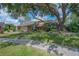 Charming front exterior featuring stone accents, lush lawn, and mature trees creating a welcoming curb appeal at 13906 Captains Reef Ct, Tampa, FL 33624
