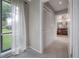 Hallway leading to a bathroom with a view of the backyard and a closet with bi-fold doors at 13906 Captains Reef Ct, Tampa, FL 33624