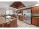 Well-equipped kitchen with stainless steel appliances, granite countertops, and a functional island under unique wood-paneled ceiling at 13906 Captains Reef Ct, Tampa, FL 33624