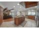 Open concept kitchen island featuring sink, stone counters, and an open floor plan leading to the living room at 13906 Captains Reef Ct, Tampa, FL 33624