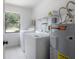 Functional laundry area equipped with modern washer, dryer, and water heater for convenience at 13906 Captains Reef Ct, Tampa, FL 33624