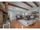 Inviting living room boasts wood floors, stone fireplace, exposed beams, and seamless flow to the kitchen at 13906 Captains Reef Ct, Tampa, FL 33624