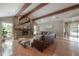 Living room with beamed ceilings, stone fireplace, hardwood floors, and large windows, creating a welcoming atmosphere at 13906 Captains Reef Ct, Tampa, FL 33624