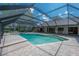 Outdoor pool with paved patio and screened lanai with seating and a bar at 13906 Captains Reef Ct, Tampa, FL 33624