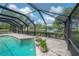 Pool with waterfall feature, stone accents, and view of the lake at 13906 Captains Reef Ct, Tampa, FL 33624
