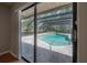 Outdoor pool surrounded by a screened enclosure with brick-paved pool deck at 13906 Captains Reef Ct, Tampa, FL 33624
