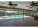 Screened-in pool area featuring a brick-paved deck, ceiling fans, and lush greenery views at 13906 Captains Reef Ct, Tampa, FL 33624