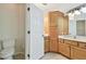Bathroom with tile flooring, toilet, and wood vanity with marble countertop at 14537 Mirabelle Vista Cir, Tampa, FL 33626
