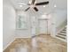 Bright living room features neutral decor, tile flooring, ceiling fan, and convenient access to the outdoors at 14537 Mirabelle Vista Cir, Tampa, FL 33626