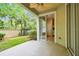 Cozy covered patio with ceiling fan, sliding glass doors, and view of the landscaped yard at 14537 Mirabelle Vista Cir, Tampa, FL 33626