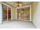 This cozy covered patio features a ceiling fan and sliding glass doors to the indoor living space at 14537 Mirabelle Vista Cir, Tampa, FL 33626