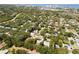 A high aerial view shows tree-lined streets and upscale homes in a mature neighborhood near the coast at 1486 Mahogany Ln # 703, Palm Harbor, FL 34683