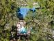 Aerial shot of backyard pool, hot tub, and a tennis court surrounded by lush green trees at 1486 Mahogany Ln # 703, Palm Harbor, FL 34683