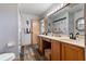 Well-lit bathroom featuring double sinks, wood cabinets, and a decorative, beach-themed style at 1486 Mahogany Ln # 703, Palm Harbor, FL 34683